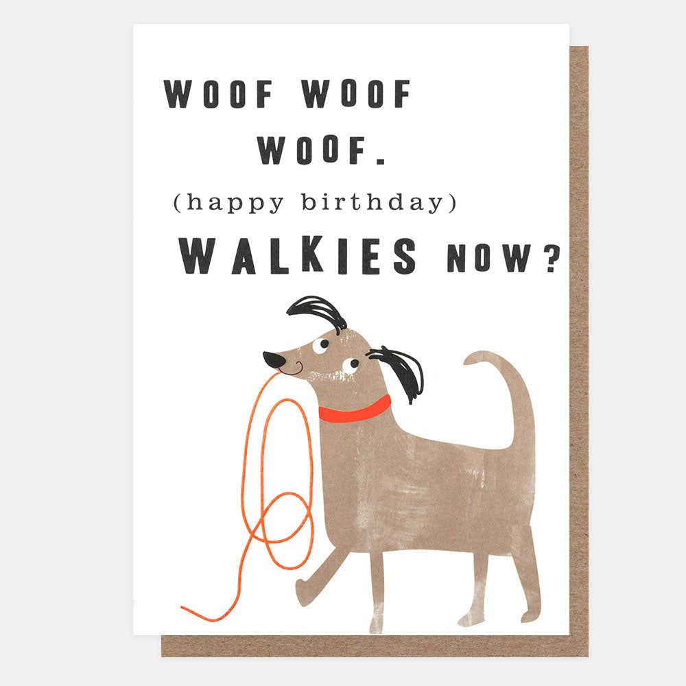 A white greeting card with a brown kraft envelope behind it, featuring the text 'WOOF WOOF WOOF. (happy birthday) WALKIES NOW?' and a cartoon dog holding an orange leash.