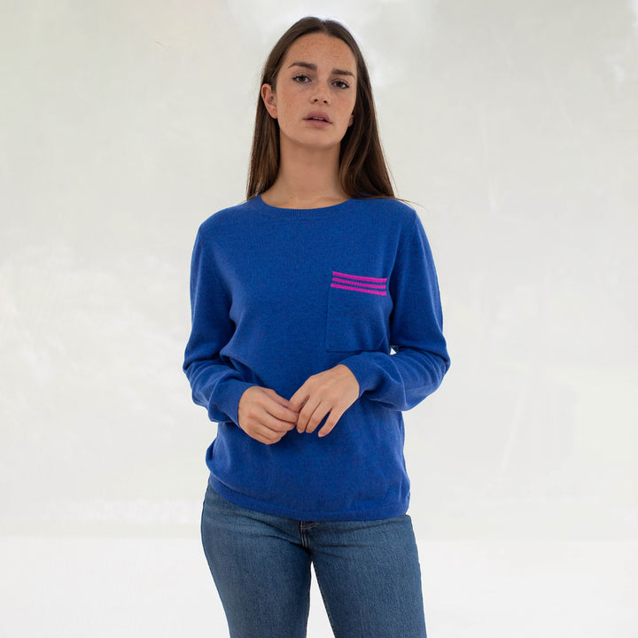 bright blue pure cashmere crew neck jumper with contrast pink stripe front pocket, made by Cocoa Cashmere