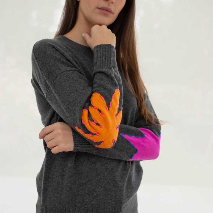 grey crew neck pure cashmere jumper with intarsia embroidered orange and pink shapes on elbows, made by Cocoa cashmere