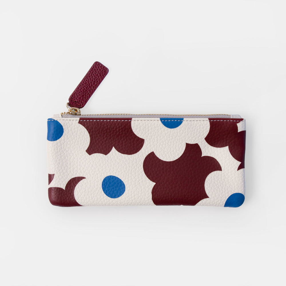 A small zippered pouch with a cream background and an abstract pattern of dark red, white, and blue flowers, featuring a dark red zipper pull tab.