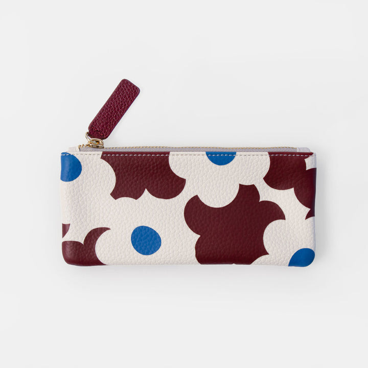 A small zippered pouch with a cream background and an abstract pattern of dark red, white, and blue flowers, featuring a dark red zipper pull tab.