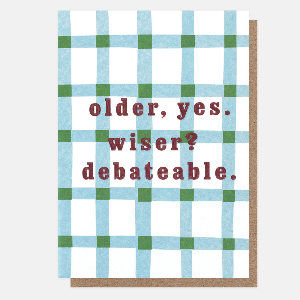 A greeting card with a white background, a blue and green plaid pattern, and the text 'older, yes. wiser? debateable.