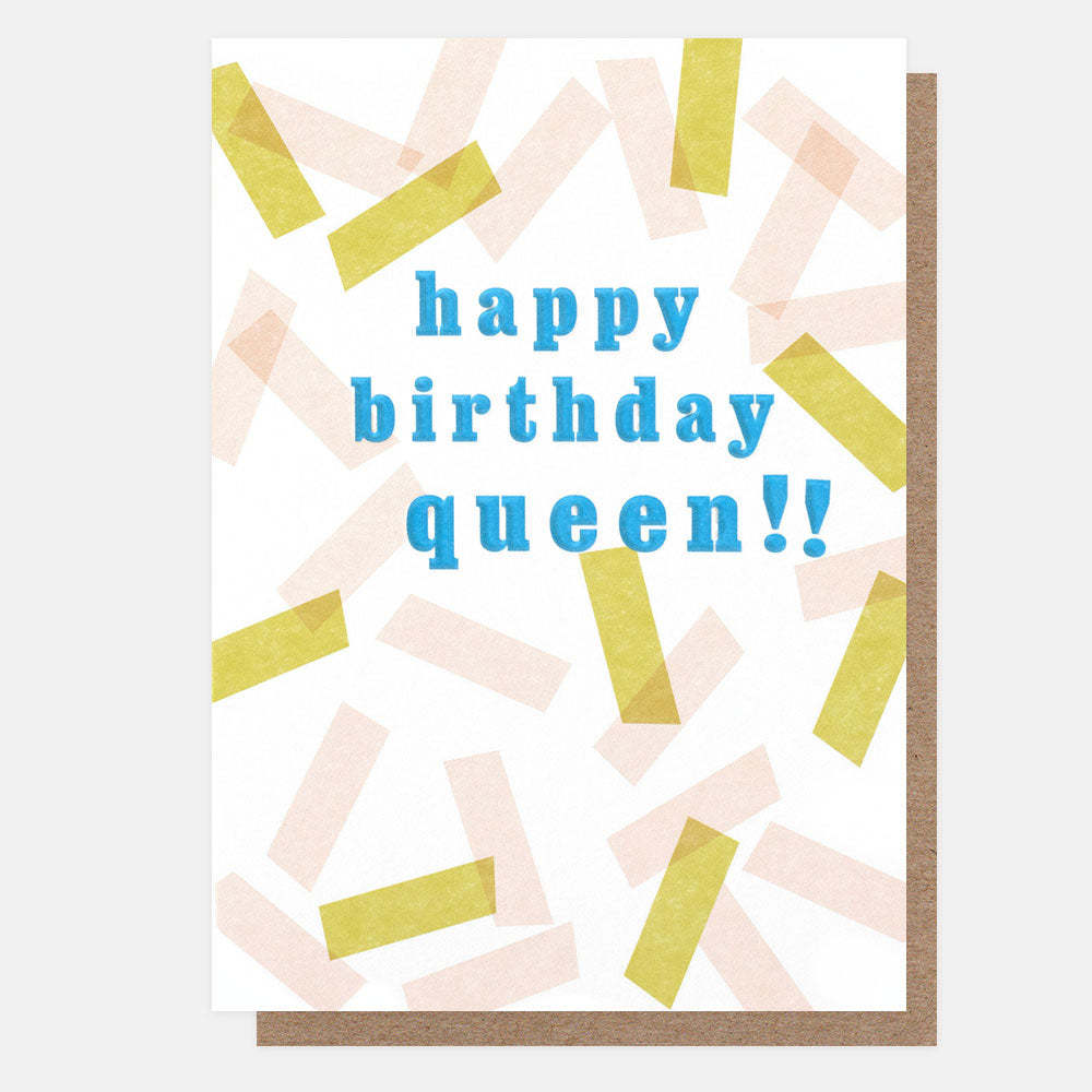 A greetings card with scattered pink and yellow confetti on a white background and the text 'happy birthday queen!!' in blue embossed lettering, shown with a brown kraft envelope behind it.