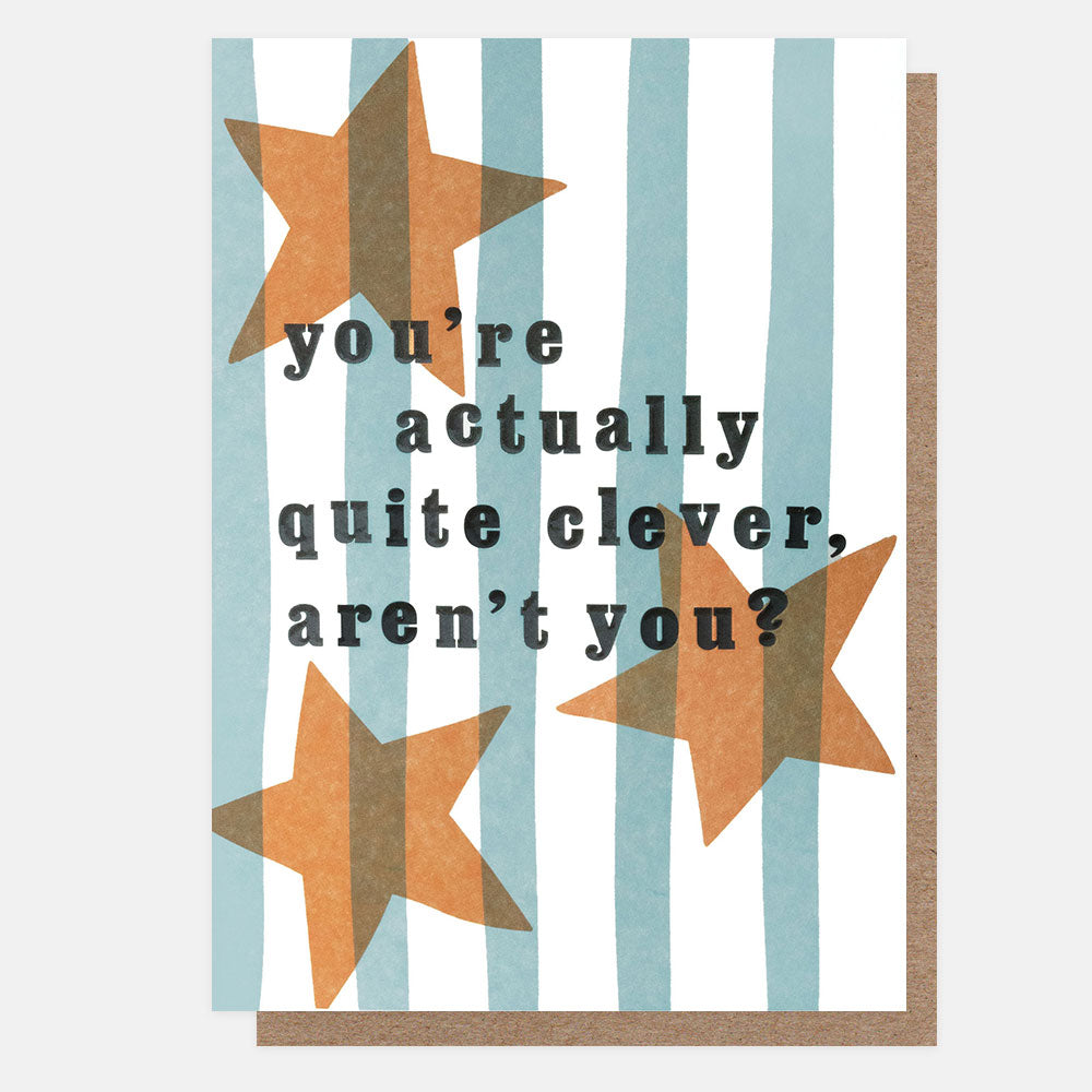 A greetings card with orange stars on blue and white vertical stripes and the text 'you're actually quite clever, aren't you?' in black embossed lettering, shown with a brown kraft envelope behind it.