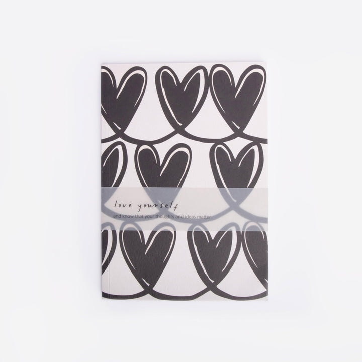 Notebook with black heart pattern on a white background