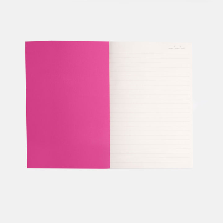 inside cover of notebook with bright pink page and a white lined page