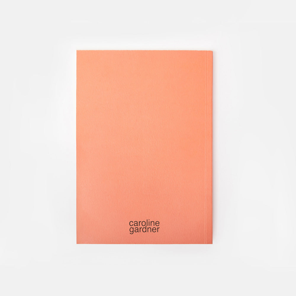 orange notebook with 'caroline gardner' branding on a white background