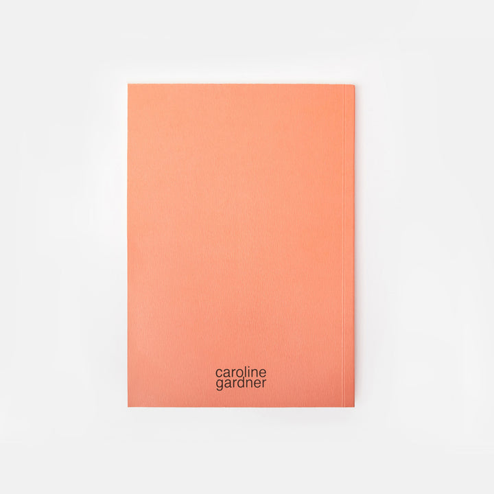 orange notebook with 'caroline gardner' branding on a white background