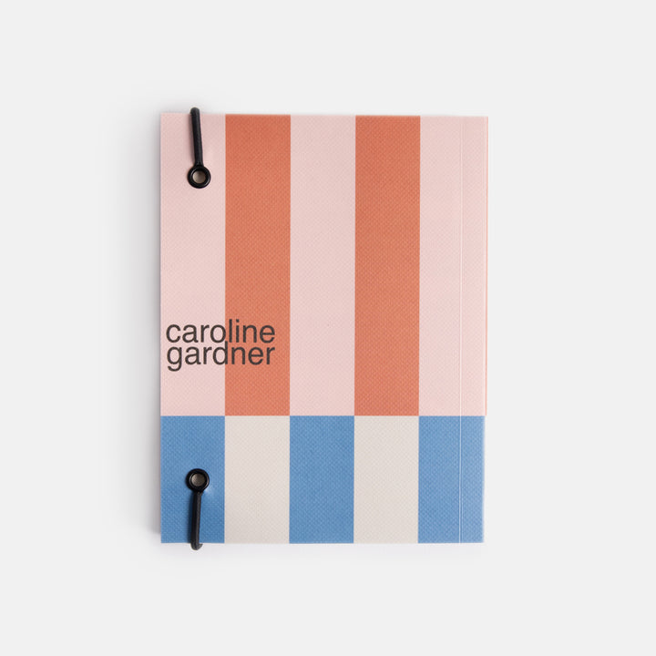 small chunky soft cover notebook with elastic strap closure and colourful offset stripe design