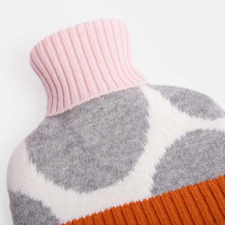 pure merino hot water bottle featuring a grey spot design on a cream base with pale pink and burnt orange trims