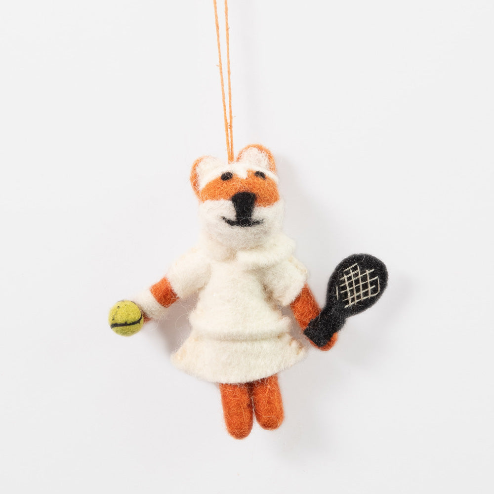 Handmade fox hanging christmas tree decoration holding a tennis racket and ball on a white background
