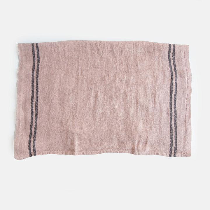 light pink washed linen tea towel with two dark stripes at either end