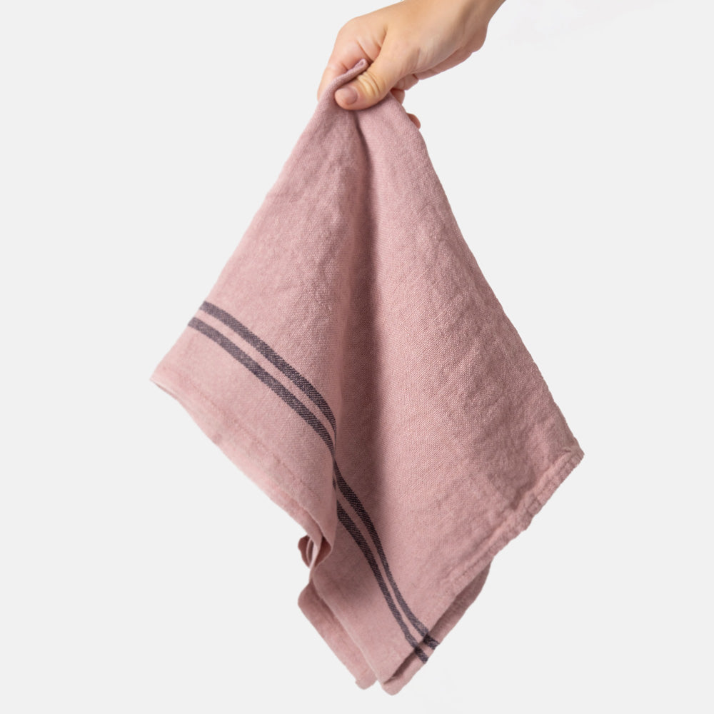 light pink washed linen tea towel with two dark stripes at either end