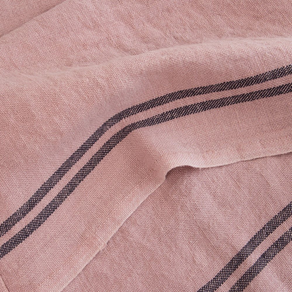 light pink washed linen tea towel with two dark stripes at either end