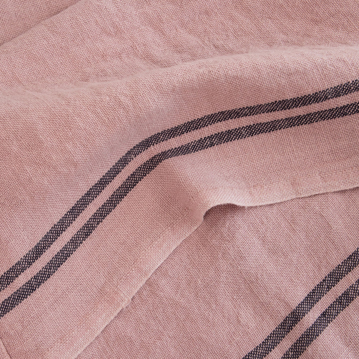 light pink washed linen tea towel with two dark stripes at either end