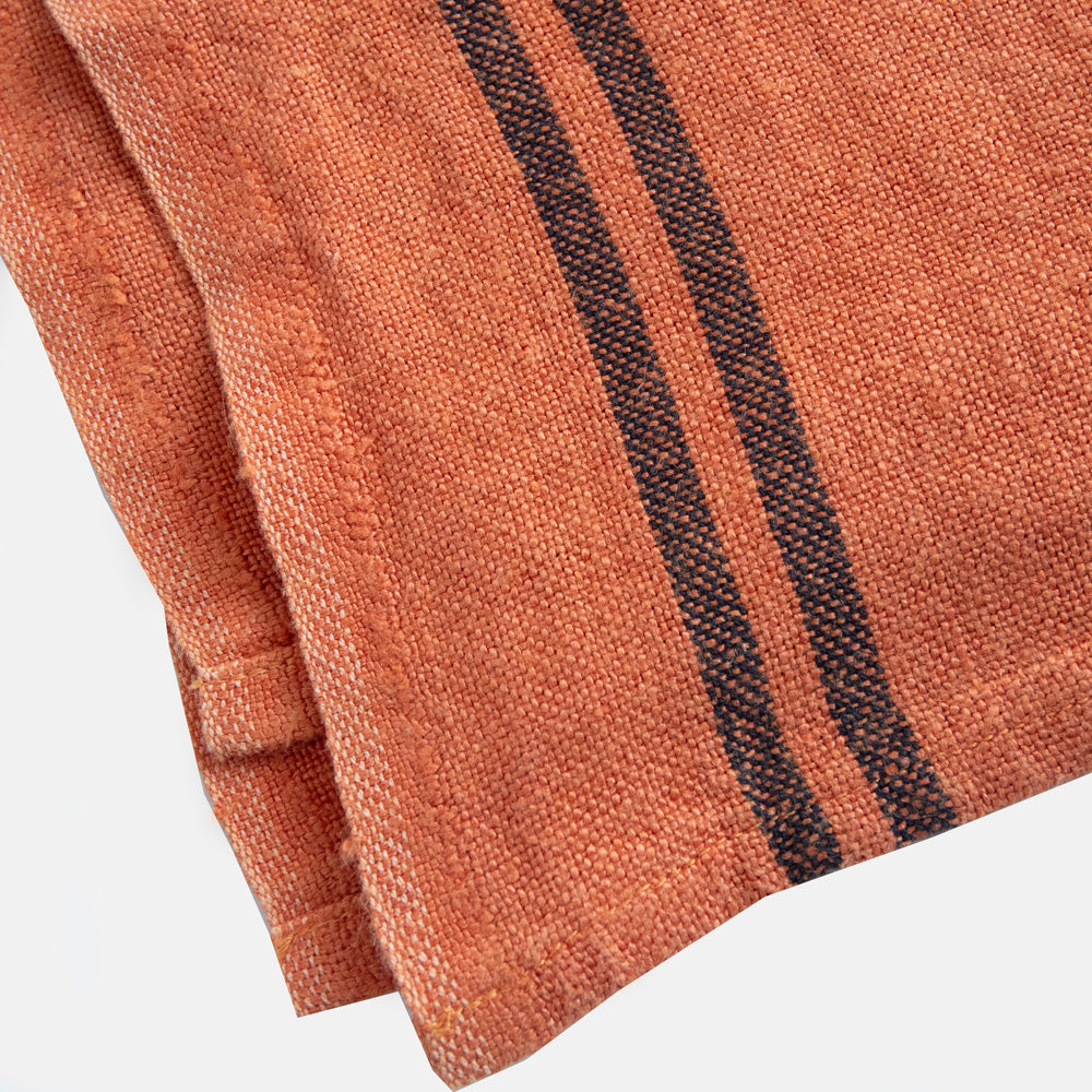 orange linen tea towel with 2 dark stripes at either end