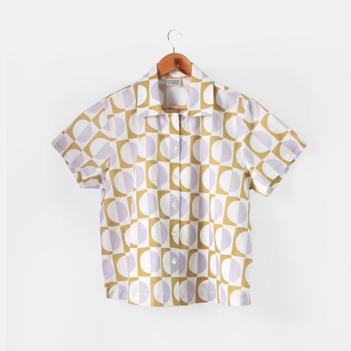 Short-sleeve shirt with geometric pattern on a hanger against a white background