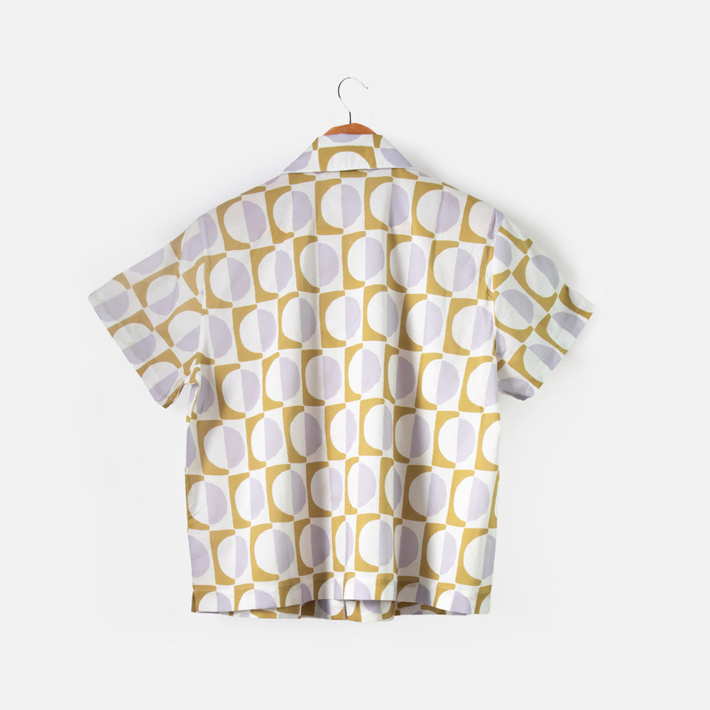 Short-sleeve shirt with geometric pattern on a hanger against a white background