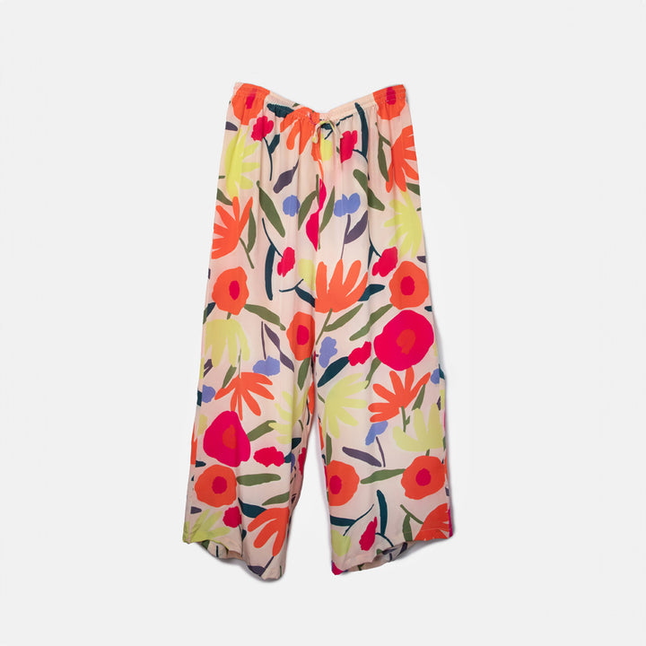 colourful abstract floral print silk palazzo pants or lounge trousers on a pale pink base