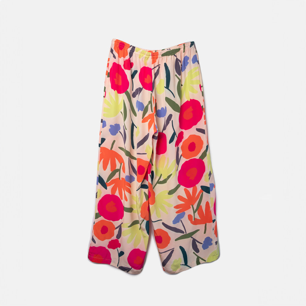 colourful abstract floral print silk palazzo pants or lounge trousers on a pale pink base