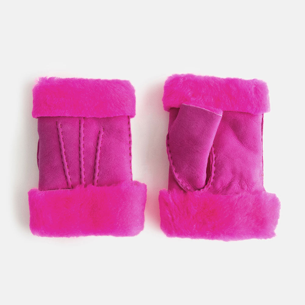 pair of women's sheepskin shearling wrist warmers in bright pink