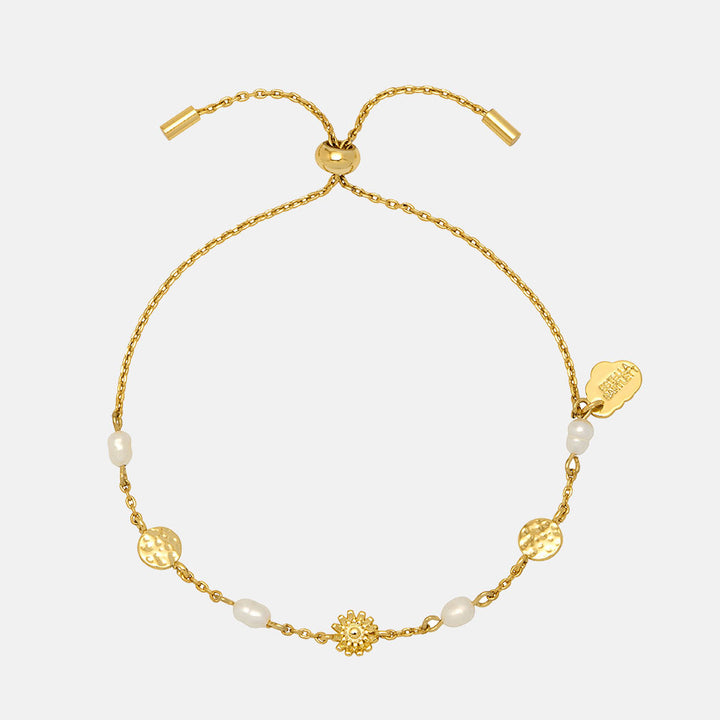 gold plated fine bracelet with 2 hammered disc charms, 1 flower charm and 4 pearls, with an adjustable slider