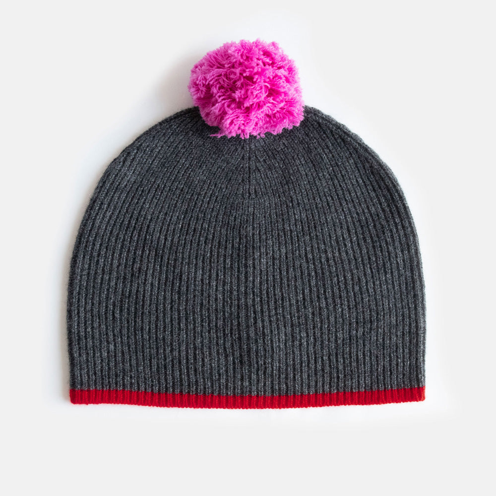 women's dark grey fine rib beanie hat with red trim and bright pink pom pom