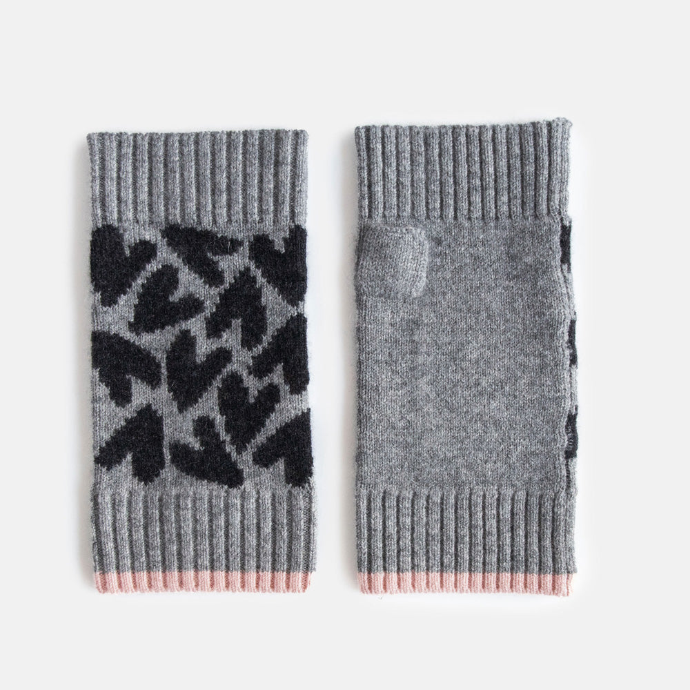 Grey wrist warmers with black hearts design on a white background