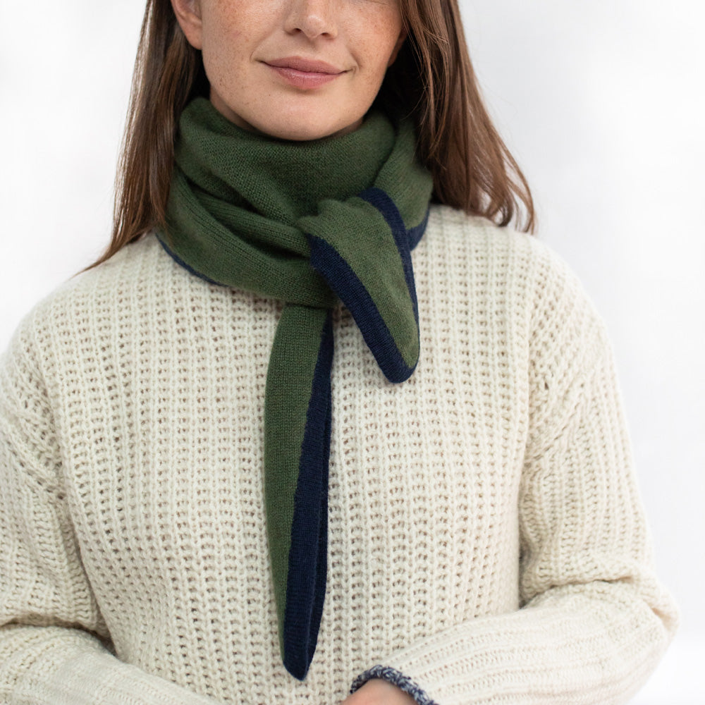 Woman wearing a green and navy scarf with a white background