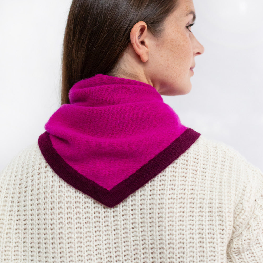 Person wearing a bright pink scarf with a white background