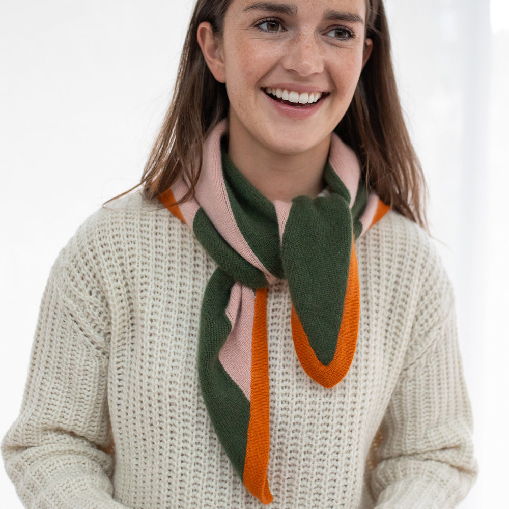 Woman wearing a green and orange scarf on a white background
