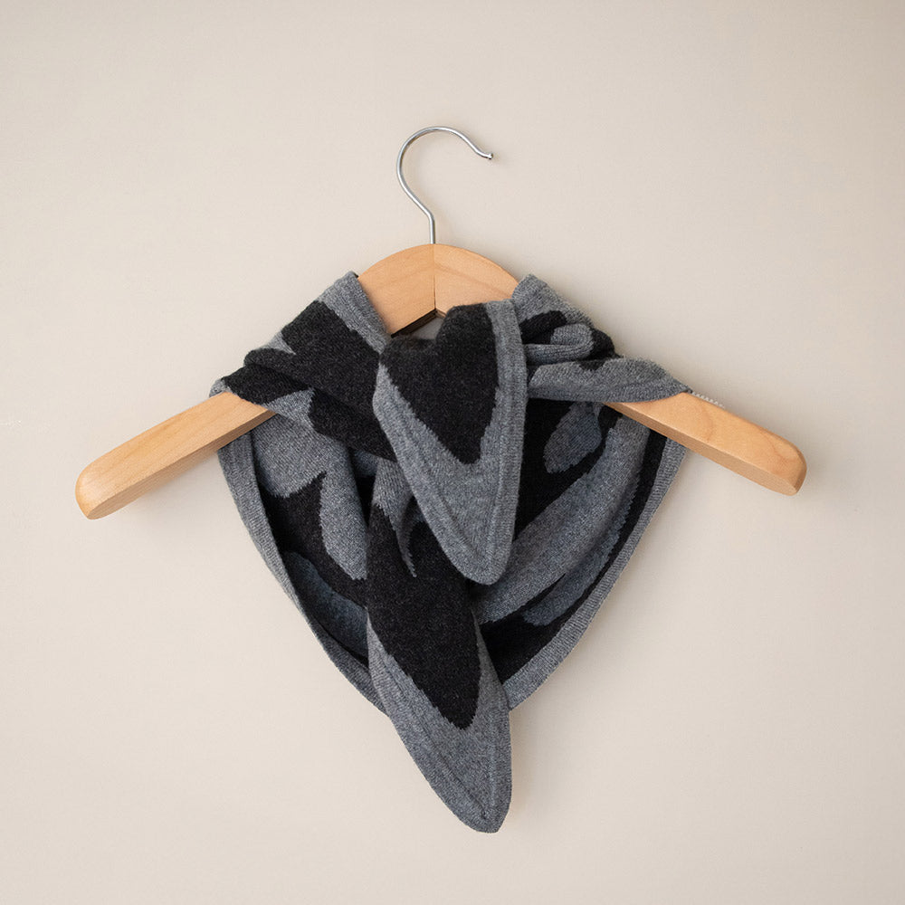 women's cashmere triangle scarf in light grey with dark grey hearts design on a coat hanger