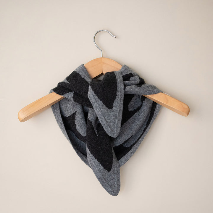 women's cashmere triangle scarf in light grey with dark grey hearts design on a coat hanger