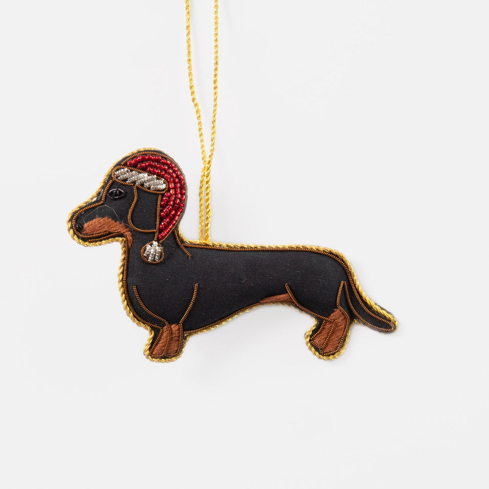Decorative dachshund hanging christmas tree decoration with a red santa hat