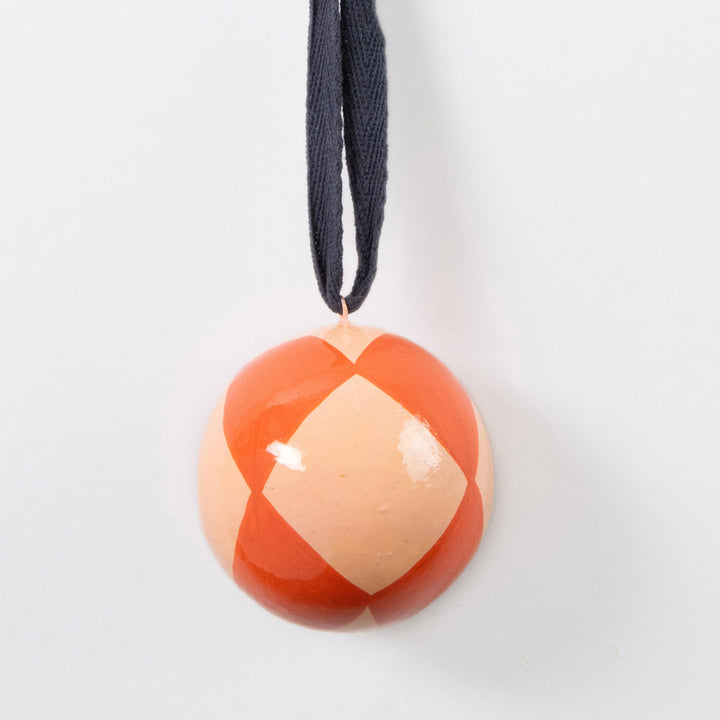pink & dark orange harlequin check painted bauble with navy cotton hanging loop