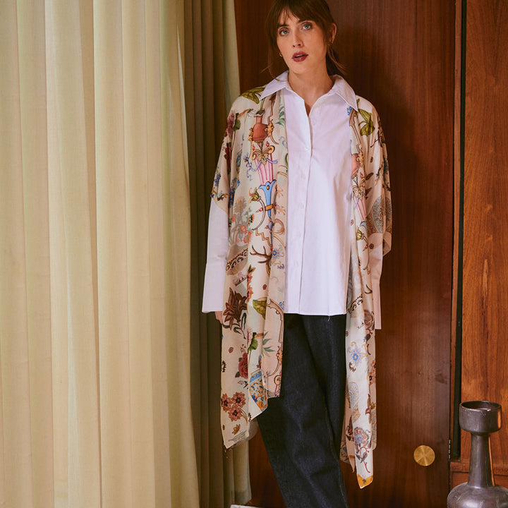 women's throwover top featuring a design of assorted objects, animals and flowers on an off white background