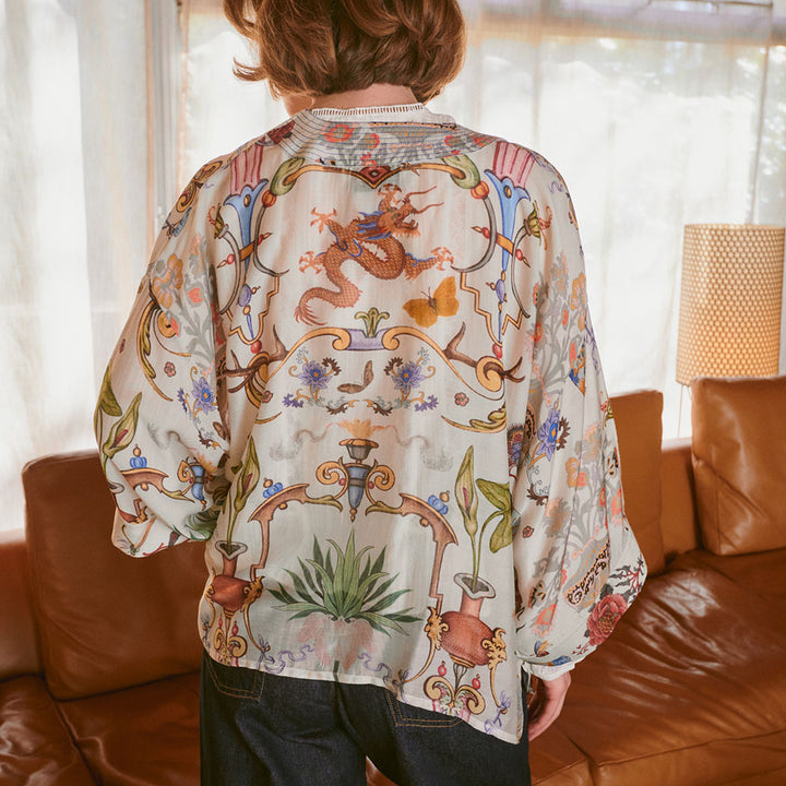 women's short kimono featuring a design of assorted objects, animals & flowers on an ivory base