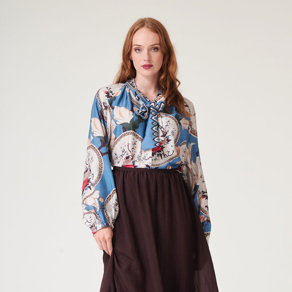 women's tie neck pussy bow shirt blouse featuring print of decorative floral plates and white magnolia on a bright blue base