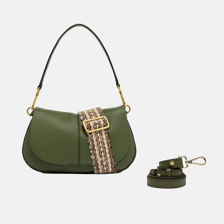 dark green pebbled leather baguette saddle bag with grab handle, webbing crossbody strap, and replacement green leather strap