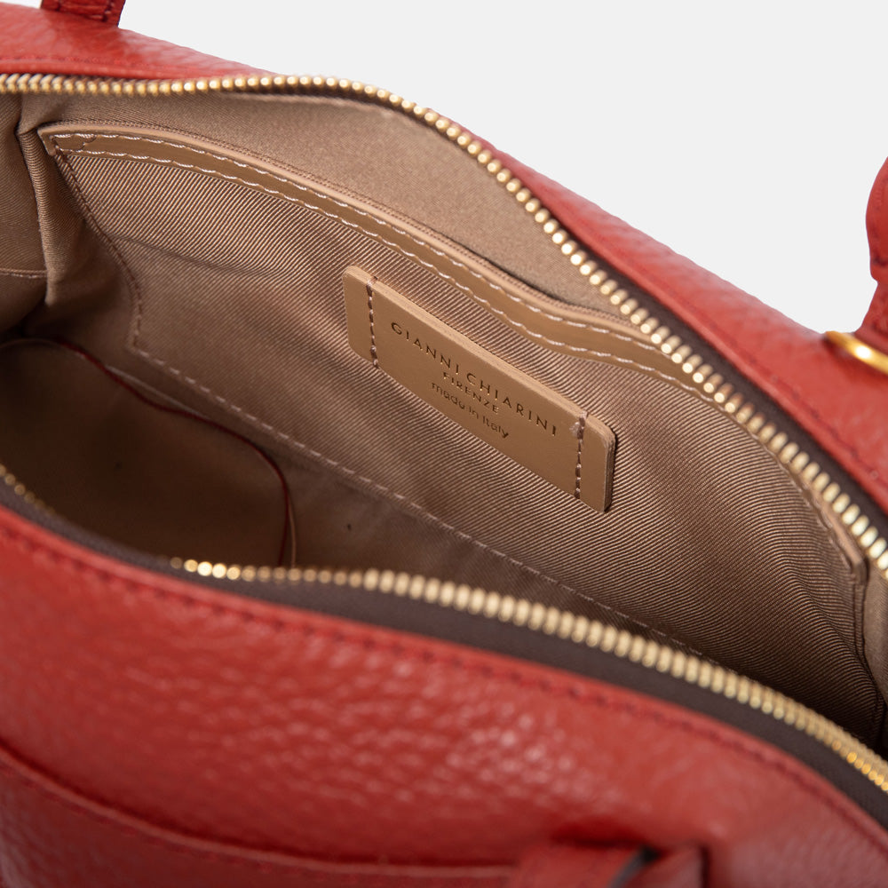brick red pebbled leather handbag with canvas lined internal compartment