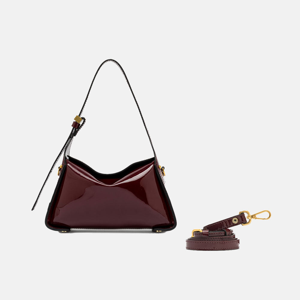 burgundy patent leather handbag with top grab handles and matching leather crossbody strap