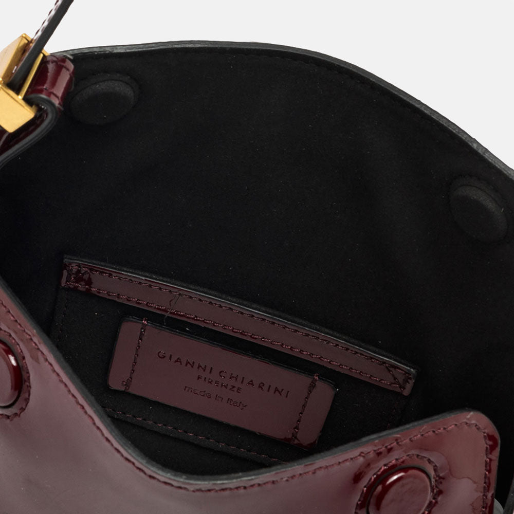 burgundy patent leather handbag with canvas lined internal compartment