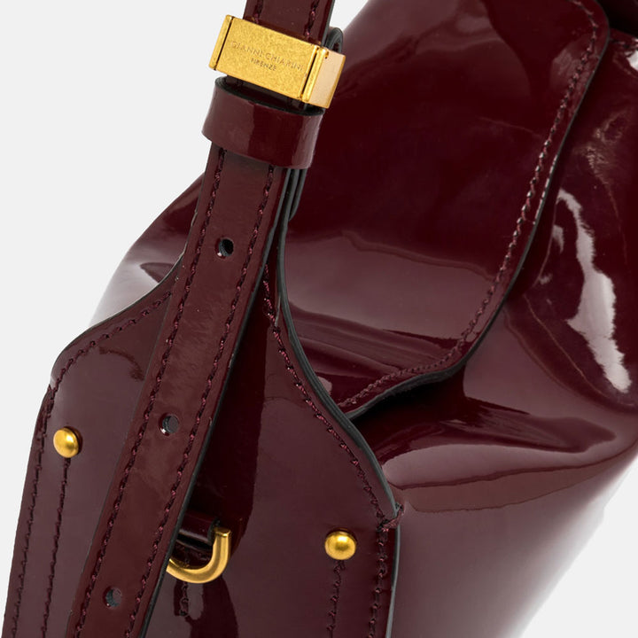 burgundy patent leather handbag with gold hardware