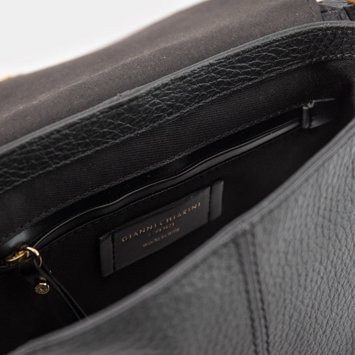 Close-up of a textured black handbag with a brand label.