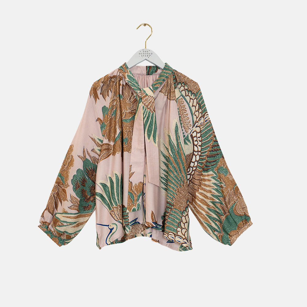 women's tie neck pussy bow shirt blouse featuring print of cranes in green, brown & blue on a pale pink base