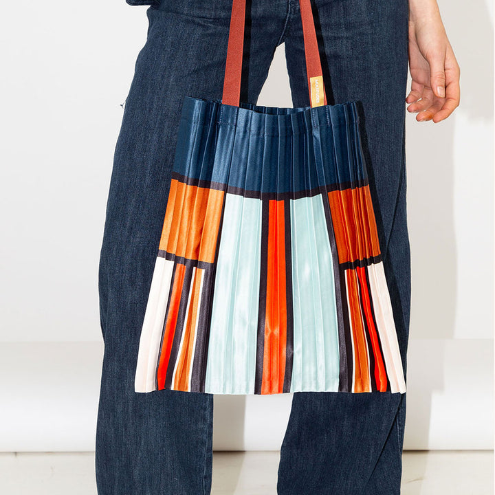 satin pleated tote bag in block stripe and check design in blue. orange, red and cream with burgundy handles