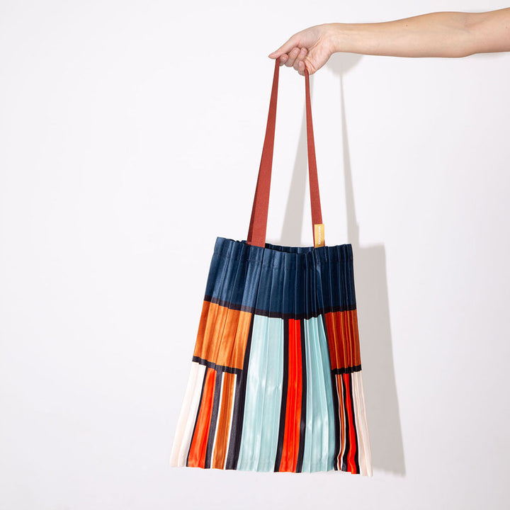 satin pleated tote bag in block stripe and check design in blue. orange, red and cream with burgundy handles