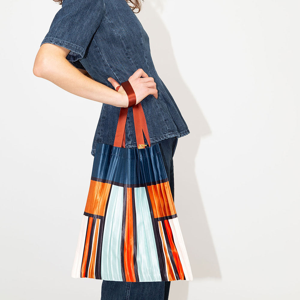 satin pleated tote bag in block stripe and check design in blue. orange, red and cream with burgundy handles