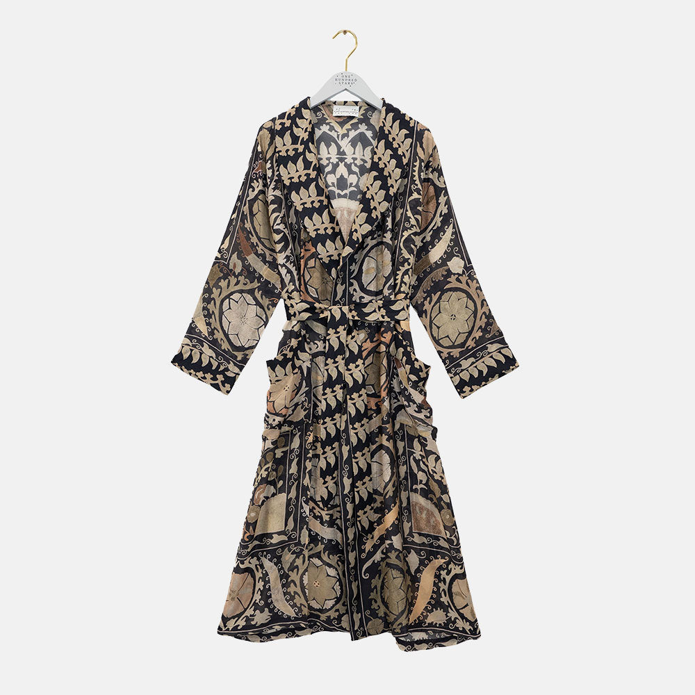 Patterned dressing gown on a hanger against a white background