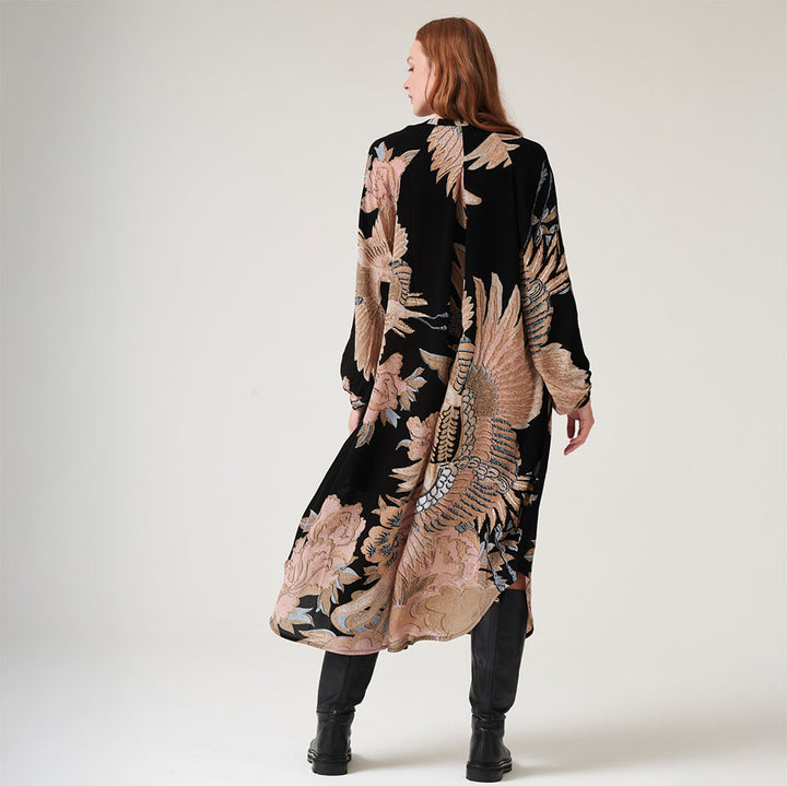 matt black crepe mid length dress with crane print in sand & light pink, worn with black boots